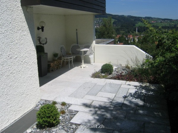 Hauszugnag mit Platten und Steingarten